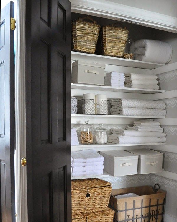 Linen closet / bathroom closet organization for a family. Stackable bins  and a rack on the door help maximize storage and keep everyone's…