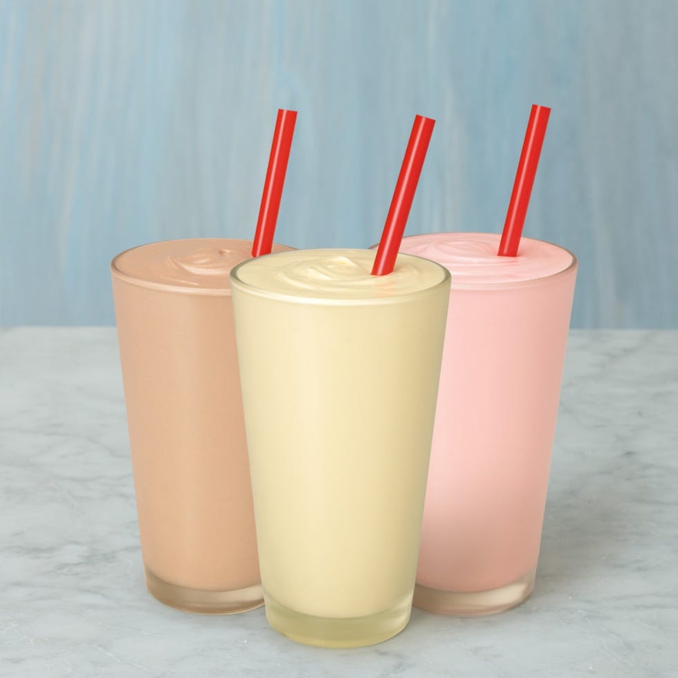 Banana, strawberry and chocolate milkshake in plastic cup with