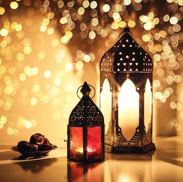 what is ramadan ornamental lanterns with burning candles and plate with date fruit on the table for muslim holiday ramadan