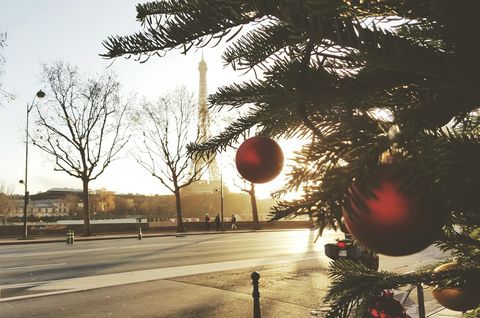 ornaments hanging on christmas tree by road and eiffel tower against sky
