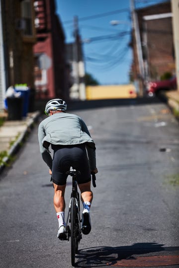 a person riding a bicycle uphill with strong muscles