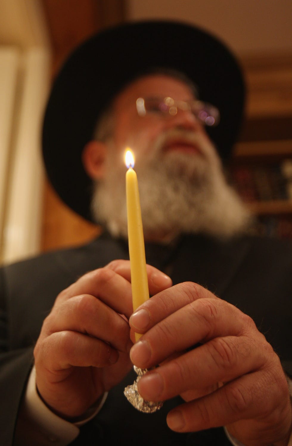 a lit candles being held in hands