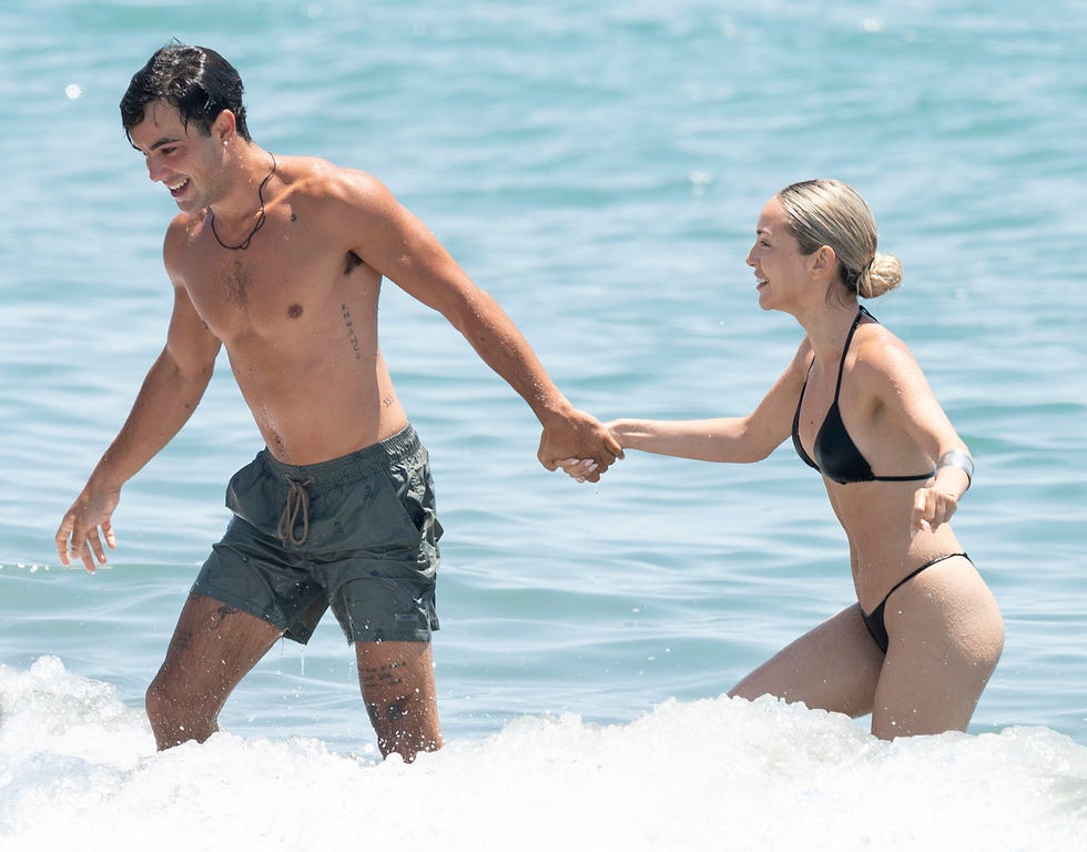 oscar casas coge de la mano a ana mena para salir del agua en una playa de marbella
