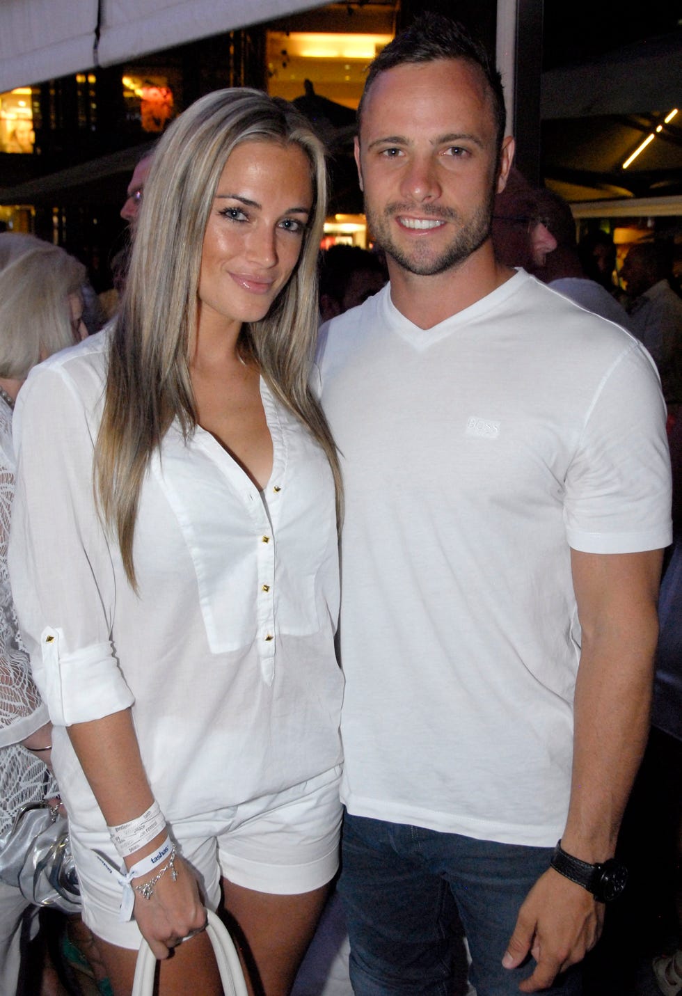 reeva steenkamp and oscar pistorius smile at the camera while standing next to each other, both wear white shirts