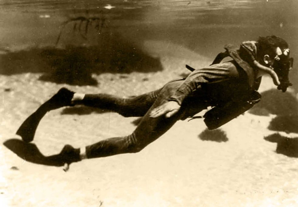 a member of the oss's maritime unit swims underwater with an early scuba device and flexible fins developed specially for the clandestine service