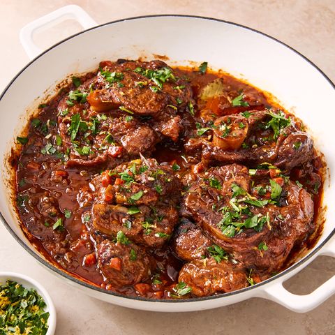 osso buco stew topped with citrus herb gremolata in a white dutch oven