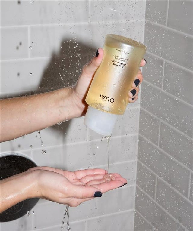 shampoo being dispensed into a hand in a shower