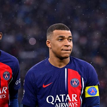 paris saint germain players ousmane dembele and kylian mbappe stand on a football pitch in the rain
