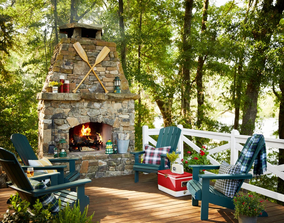 stone fireplace with adirondack chairs on a back deck