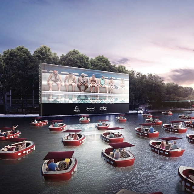 outdoor movie theater on water surrounded by boats
