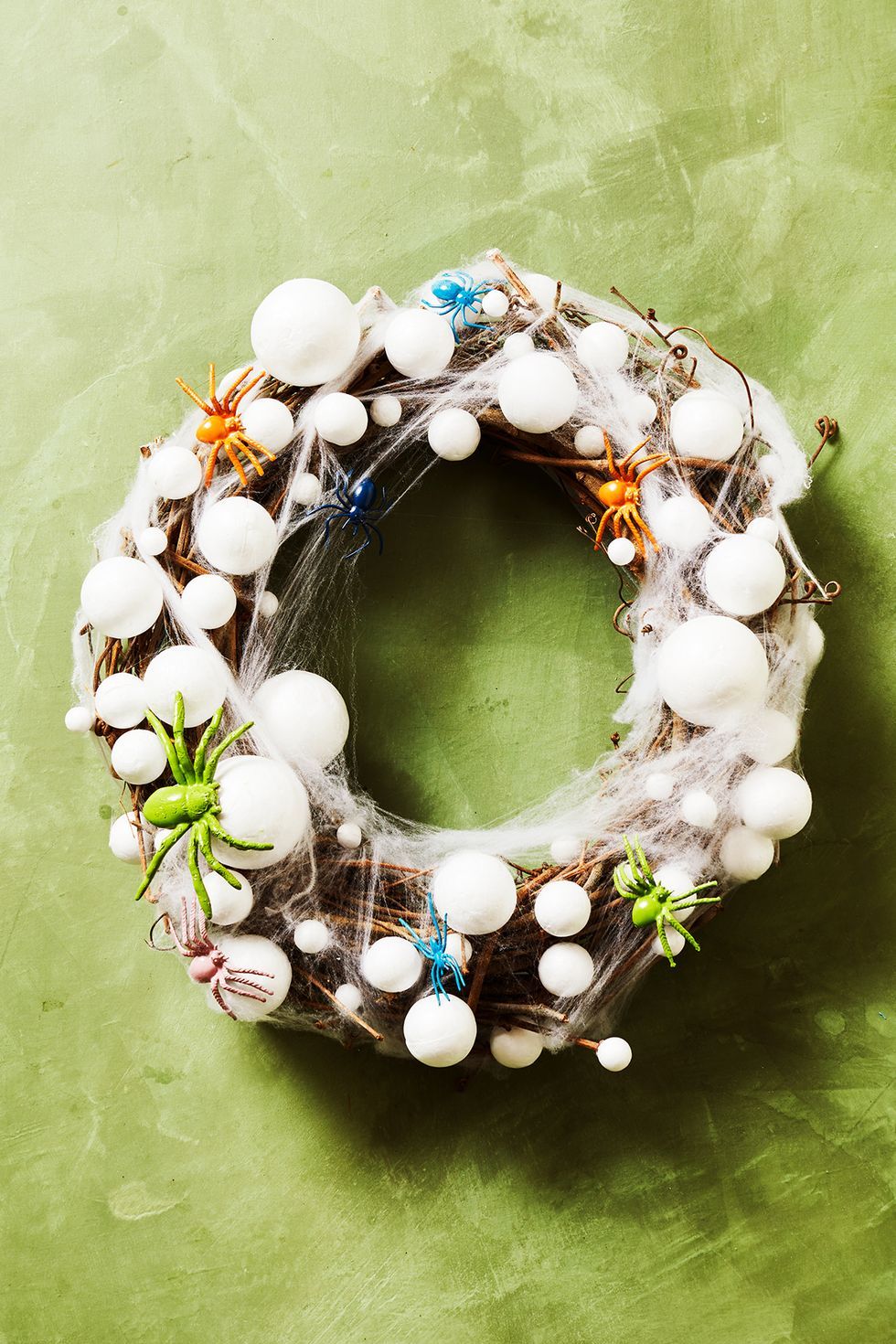 diy outdoor halloween decorations, wreath made with fake spider eggs and web