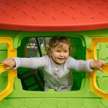 kid opening window of outdoor playhouse