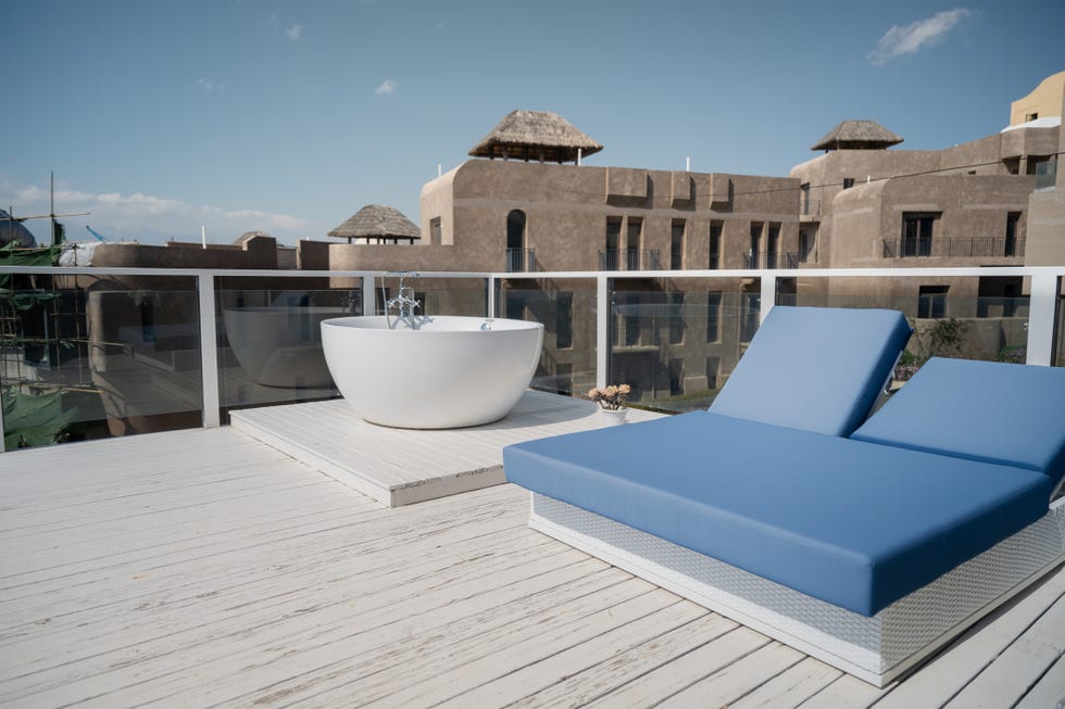 outdoor tub ideas, balcony with white bathtub and blue sofa