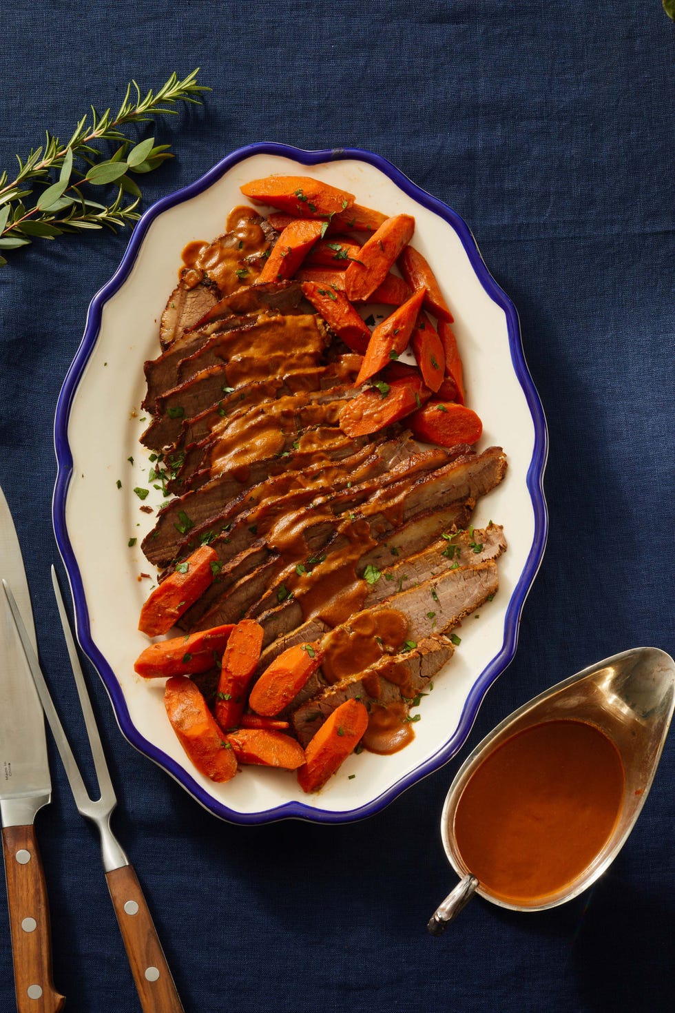 sliced braised brisket on a white platter with blue border