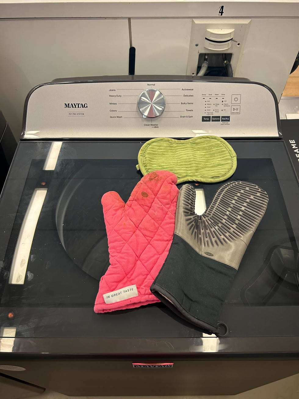 a pair of oven mitts on a washing machine