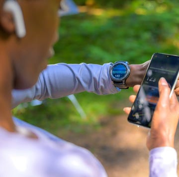 vrouw kijkt op sporthorloge en telefoon voor hartslag