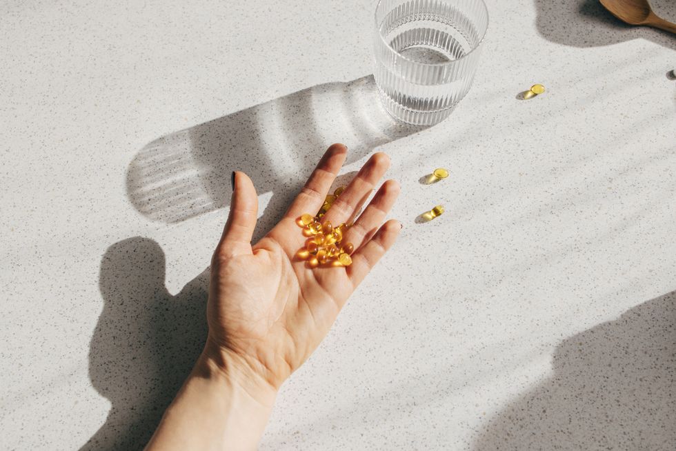 overhead shot of an anonymous person's hand holding vitamin d pills