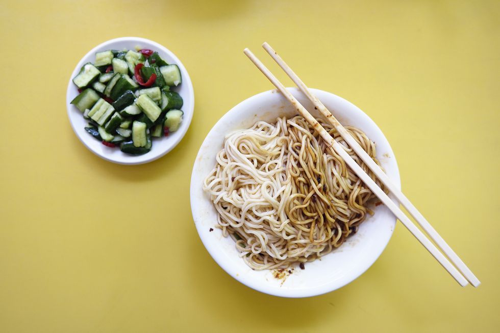 overhead view of chinese noodles on a yellow table
