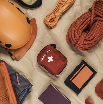 overhead view of climbing equipment with climbing helmet, first aid kit and climbing ropes