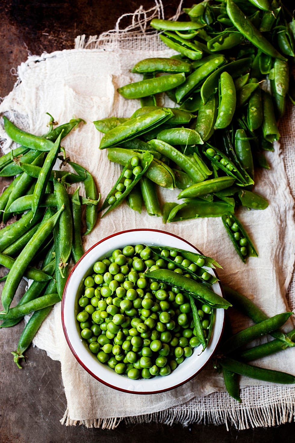 overhead view of green peas on napkin at old kitchen counter