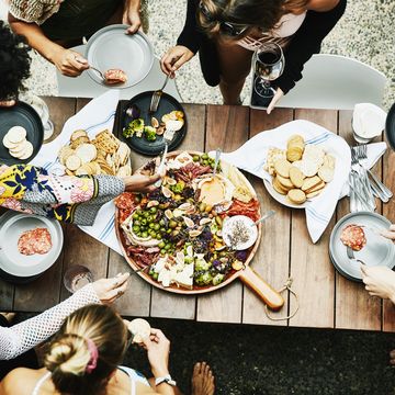 overhead view of group of friends enjoying buffet of food during party