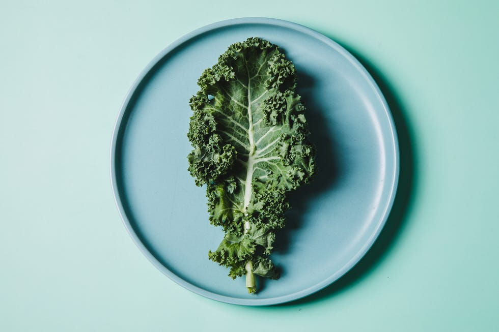 overhead view of kale on a plate against green background