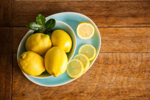 overhead view of lemons in a bowl on a wooden table