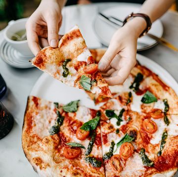 een vrouw eet een pizza