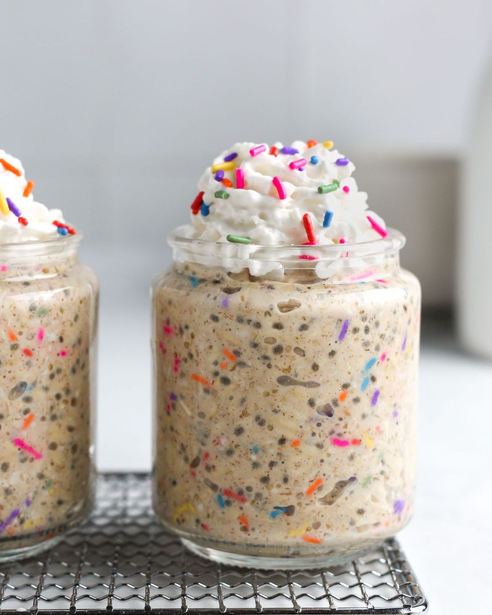 birthday cake overnight oats with whipped cream and rainbow sprinkles