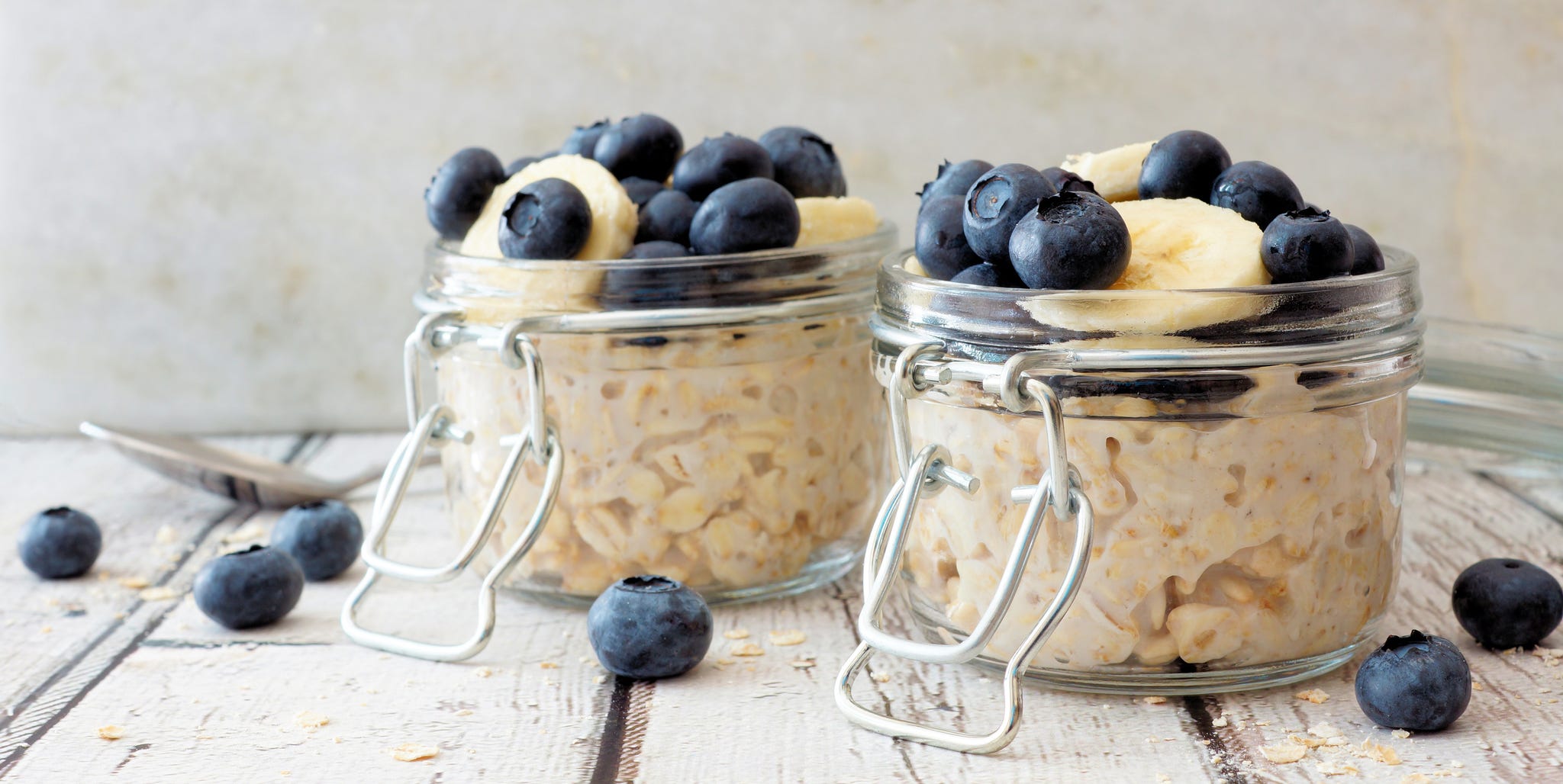 Overnight oats with blueberries and bananas on a white wood background