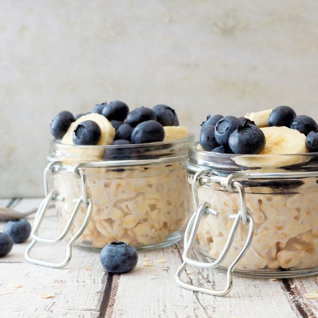Overnight oats with blueberries and bananas on a white wood background