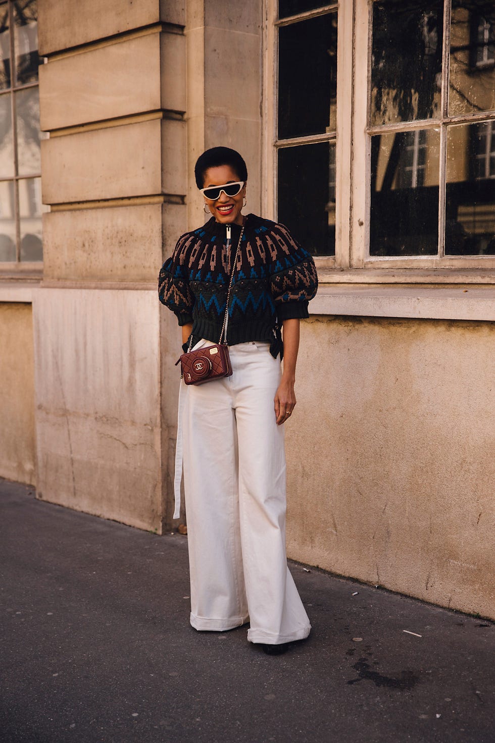 tamu macpherson wears wide leg white jeans and a patterned oversize knit