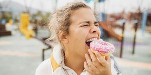 happy woman biting donut close up