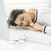 Overworked woman sleeping on desk in office