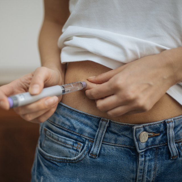 woman injects insulin in stomach