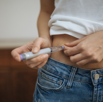 woman injects insulin in stomach