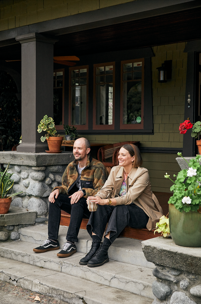 pf candle co a man and woman sitting on a stone bench in front of a building