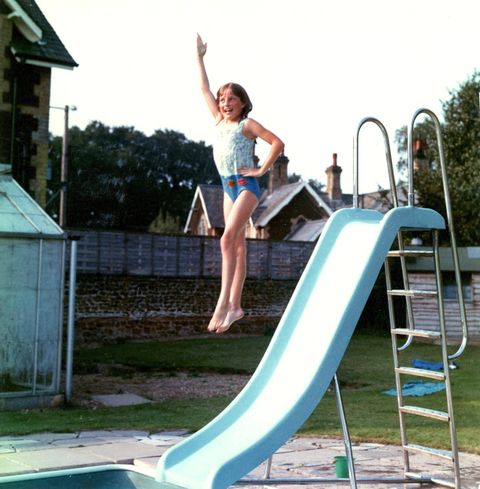 Always poised, even when jumping off a slide into the family’s pool at Park House, a youthful Diana shows off her fun side. Her red swimming badges can be seen at the bottom of her bathing suit.