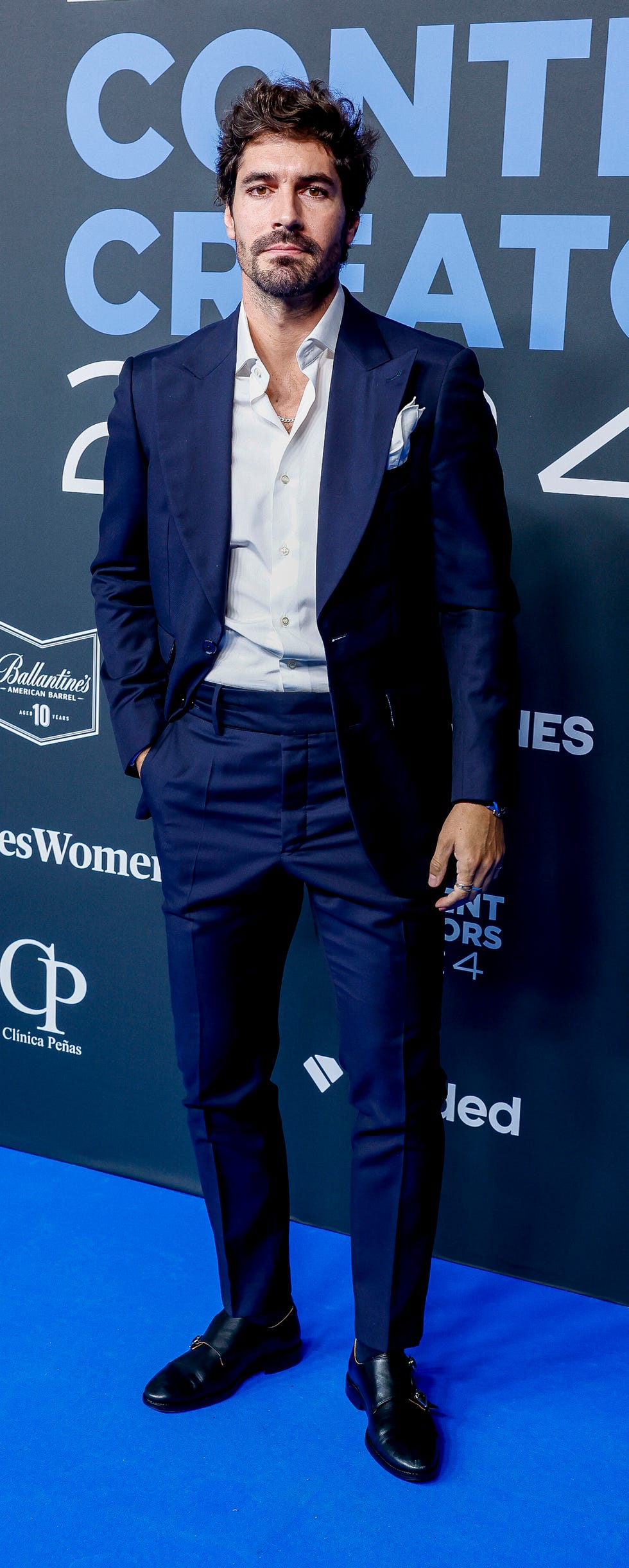 pablo garna con traje azul y camisa blanca posa en un photocall