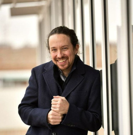 el politico pablo iglesias posando apoyado y sonriendo