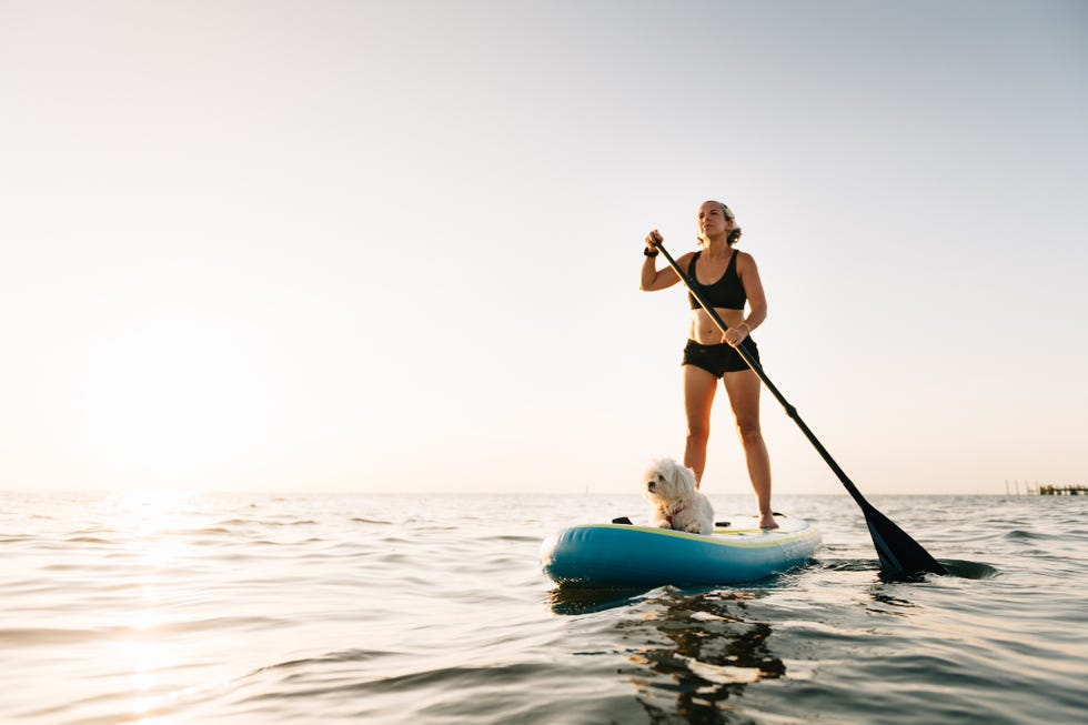 Woman paddling with Maltese