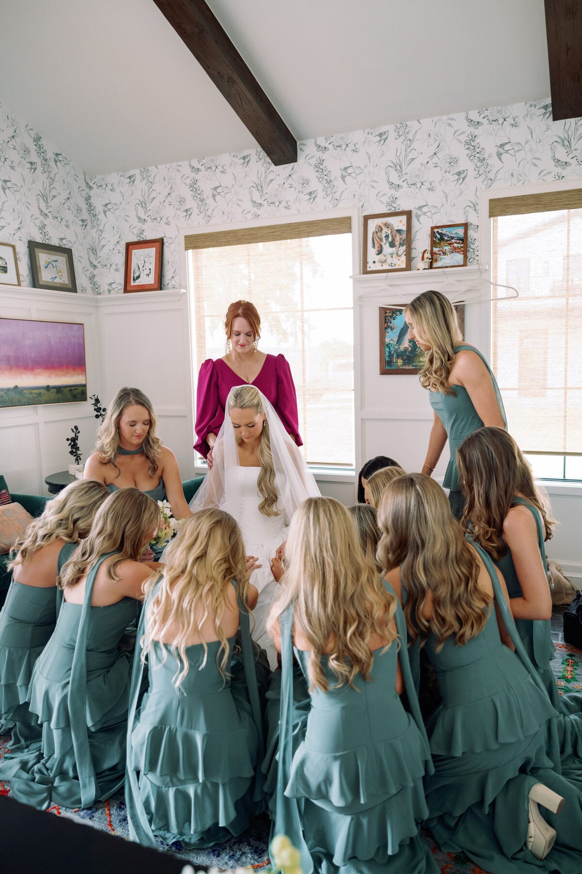 bridal party assisting the bride with her wedding dress