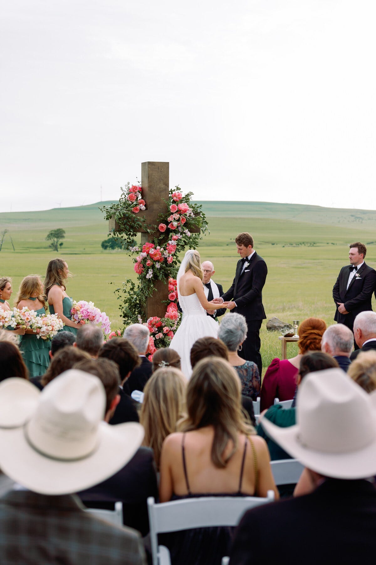 outdoor wedding ceremony featuring a cross adorned with flowers