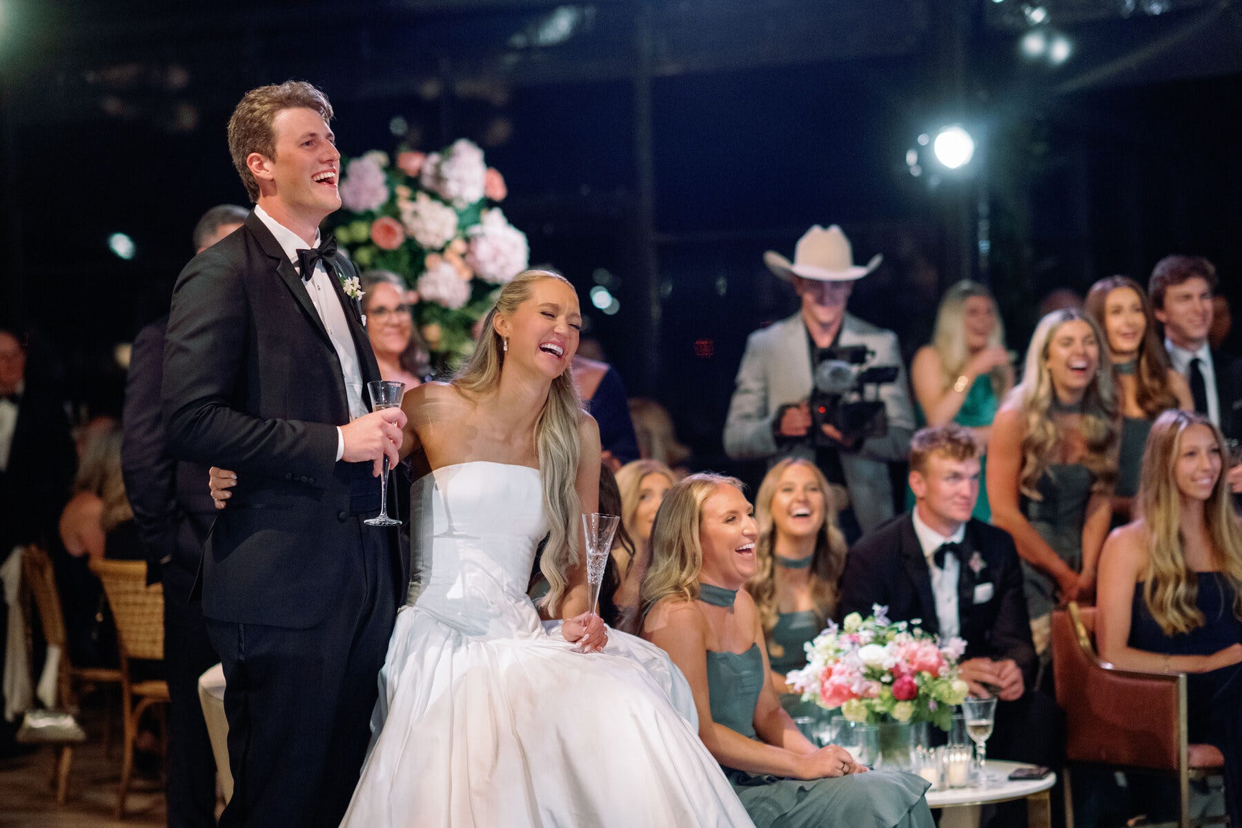 couple celebrating at a wedding reception with guests in elegant attire