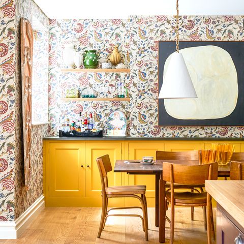 dining room with yellow cabinets and wallpaper