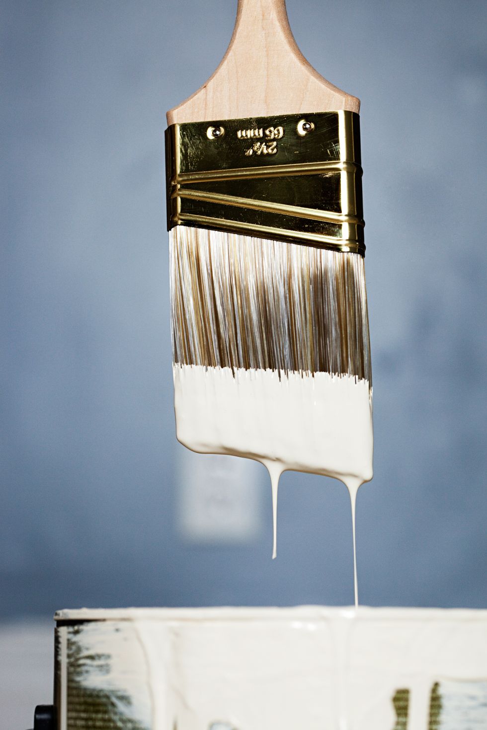 Paintbrush with white paint dripping