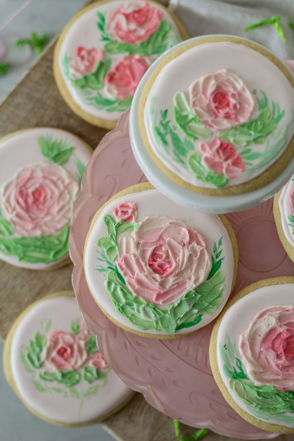 a tray of circular cookies with handpainted flowers