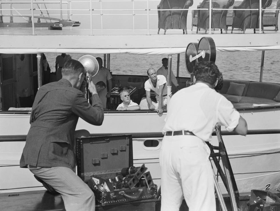 newsreel photographers capturing boat with president roosevelt