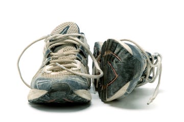 pair of old used running shoes isolated on white background