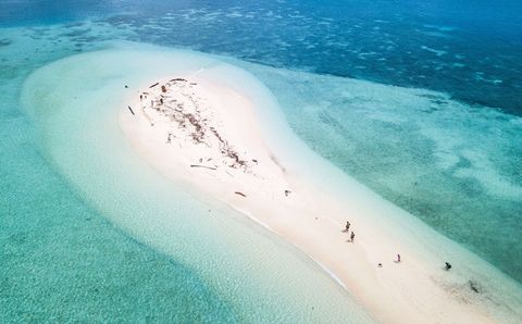Bezoekers verkennen bij laagtij een zandbank in zuidelijk Palau een afgelegen archipel tussen de Filipijnen en PapoeaNieuwGuinea